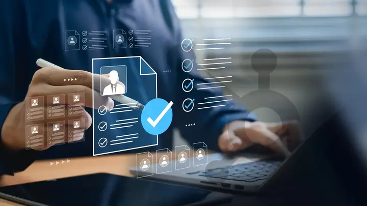 Customer records and checklist symbols over a person working at a laptop, with a subtle HubSpot sprocket.