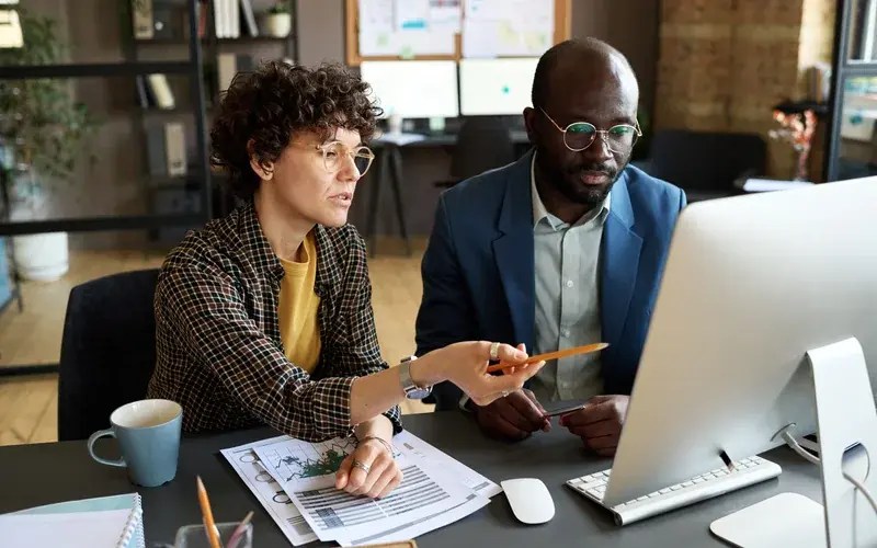 Two people reviewing information together at a computer.