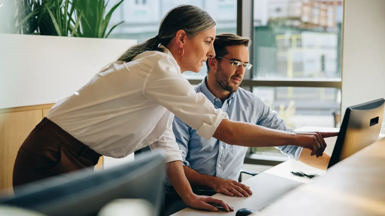 Two people reviewing work on a computer screen.